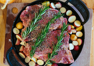 시즈닝 된 육류에 놓인 로즈마리